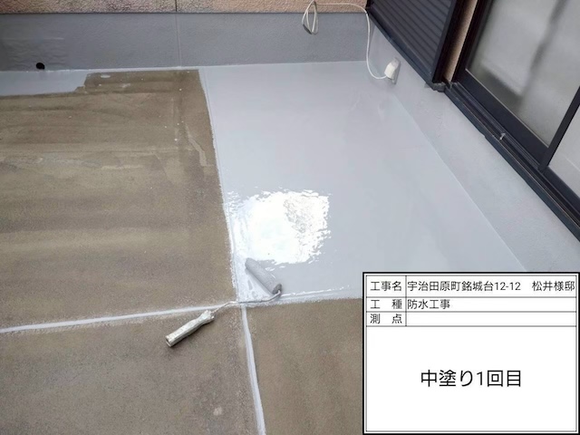 ウレタン防水材（中塗り）1層目の流し込み作業。厚みを確保し、強固な防水層を形成する重要な工程。